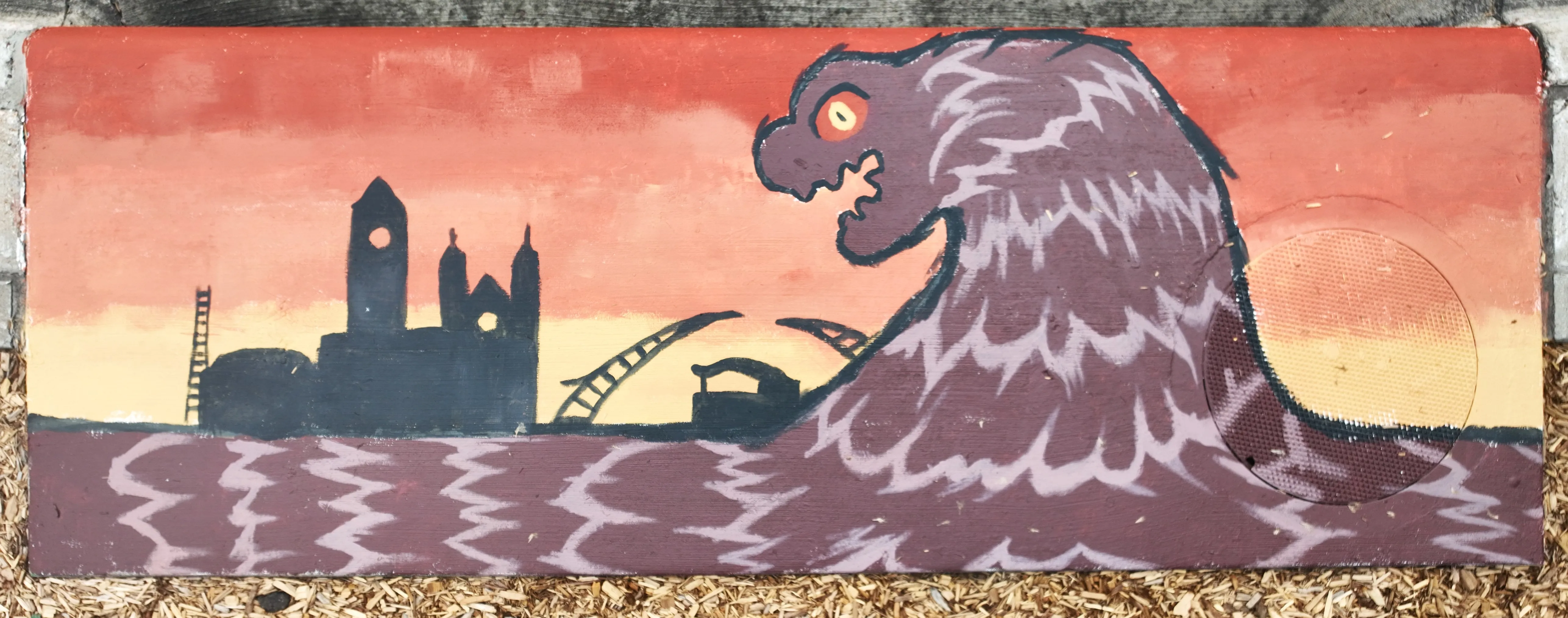 A mural on a storm inlet drain featuing a large black monster arising from a brown river, menacingly hovering over Sioux Falls landmarks like the Courthouse Museum and Arc of Dreams.
